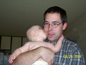 Aiden is kissing daddy on the cheek.