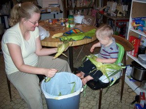 Helping mommy shuck corn.