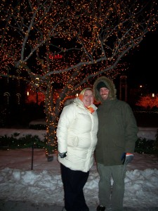 Erica and Matt in front of the orange lit tree.