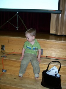 Sitting on the stairs in front of the stage.